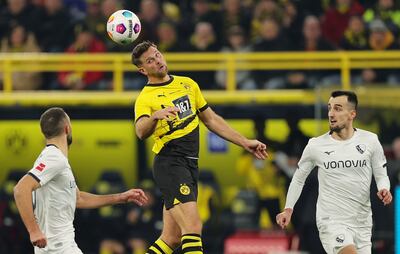 Niclas Füllkrug, delantero del Borussia Dortmund, cabecea el balón ante la presencia de dos jugadores del Bochum.