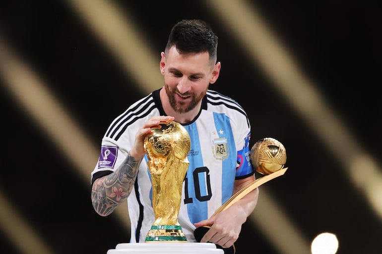 Lionel Messi, de Argentina, toca el trofeo de la Copa Mundial al pasarlo tras ganar el Balón de Oro durante la ceremonia de premiación posterior a la final de la Copa Mundial de la FIFA 2022 entre Argentina y Francia en el estadio de Lusail, Lusail, Qatar, 18 de diciembre de 2022.