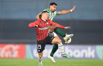 TOPSHOT - Huachipato's Paraguayan forward Cris Martinez (Front) and Racing's defender Guillermo Cotugno fight for the ball during the Copa Sudamericana knockout round playoff second leg football match between Uruguay's Racing and Chile's Huachipato at the Centenario stadium in Montevideo on July 23, 2024. (Photo by DANTE FERNANDEZ / AFP)