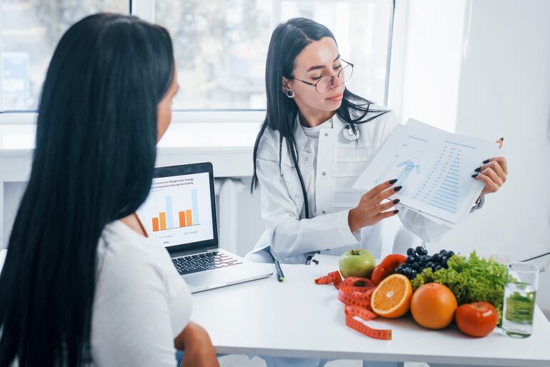 Nutricionista explica un sistema de alimentación a su paciente.