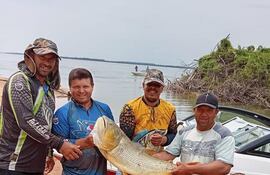 Paso de Patria: un grupo de pescadores exhiben la presa más codiciada del río Paraná, el Dorado.