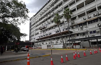 Fachada del hospital de IPS central con partes dañadas y ventanas cubiertas, sin personas visibles.