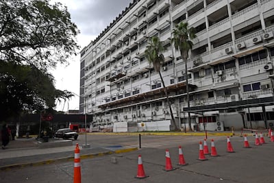 Fachada del hospital de IPS central con partes dañadas y ventanas cubiertas, sin personas visibles.