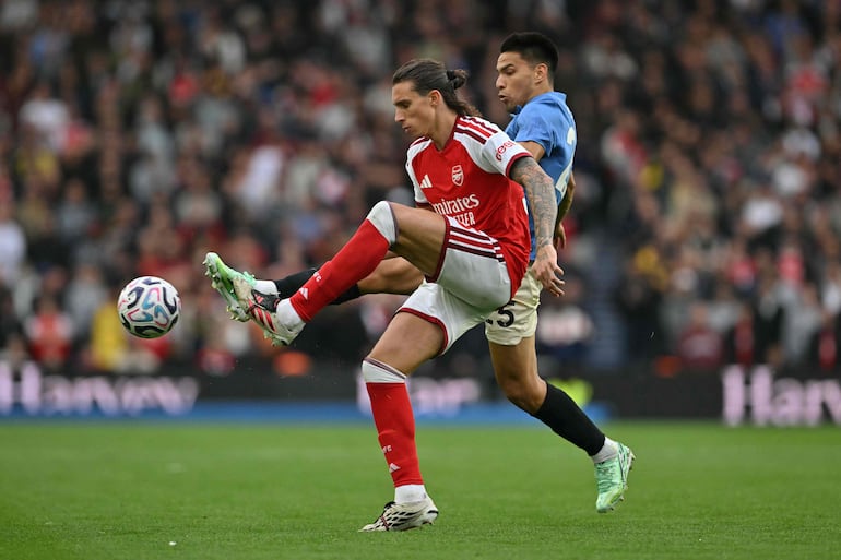 El defensa italiano del Arsenal, Riccardo Calafiori, pelea por el balón con el centrocampista paraguayo del Brighton, Diego Gómez, durante el partido de fútbol de la Premier League inglesa, en el American Express Community Stadium de Brighton.