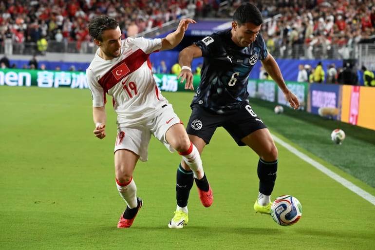 El paraguayo Junior Alonso intenta escaparse ante la marca del turco Yunus.