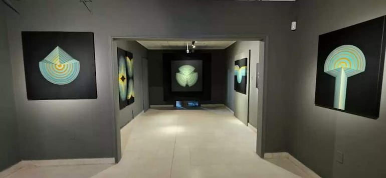 Ambiente de galería con varias obras abstractas en las paredes, iluminadas suavemente, creando un espacio para la contemplación.