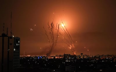 Militantes palestinos disparan una salva de cohetes desde Gaza mientras un misil israelí lanzado desde el sistema de misiles de defensa Cúpula de Hierro intenta interceptar los cohetes, disparados desde la Franja de Gaza, sobre la ciudad de Netivot en el sur de Israel el 8 de octubre de 2023.