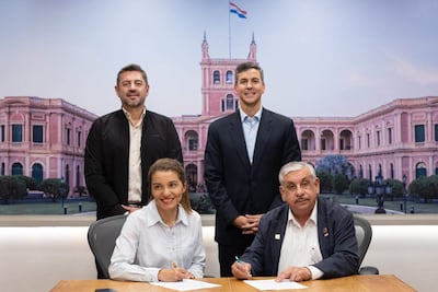 Alliana y Peña en blazers oscuros, Fretes y González en blusa blanca y oscuro, firman documentos en el Palacio de López.