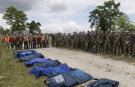 Miembros del ejercito junto a varios cuerpos recuperados a lo largo del río Narayani.
