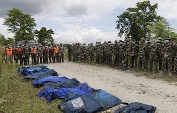 Miembros del ejercito junto a varios cuerpos recuperados a lo largo del río Narayani.