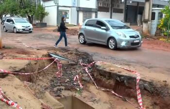 Vehículos y transeúntes esquivan el pozo que se generó a consecuencia de los raudales.