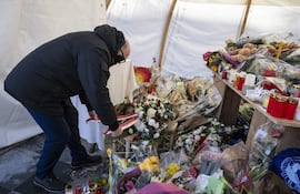 eL ministro de Defensa, Protección Civil y Deportes de Suiza, Martin Pfister, deja flores en un memorial a las víctimas del incendio en Crans Montana.