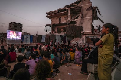 Niños palestinos desplazados internamente ven una película en un cine improvisado al aire libre, cerca de las ruinas de edificios destruidos en el barrio de Al-Sheikh Redwan, en la ciudad de Gaza, el 15 de octubre de 2026. Alrededor de 1,9 millones de personas en Gaza —casi el 90 por ciento de la población— han sido desplazadas desde que comenzó el conflicto entre Israel y Hamás en octubre de 2023, según la ONU.