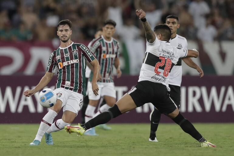 Matheus Martinelli (i), jugador de Fluminense, disputa un balón con Jorge Recalde, futbolista de Olimpia, en un partido de la Copa Libertadores 2022 en el estadio Olímpico Nilton Santos, en Río de Janeiro, Brasil.