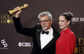 - El director brasileño Kléber Mendonca Filho (izq.) y la productora francesa Émilie Lesclaux posan en la sala de prensa con el premio a la mejor película en lengua no inglesa por "El agente secreto".