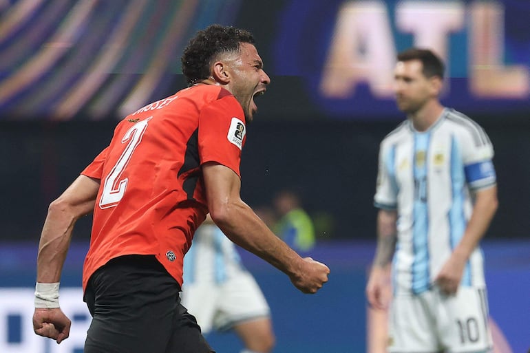 Yasser Ibrahim festeja, mientras Lionel Messi sufre.