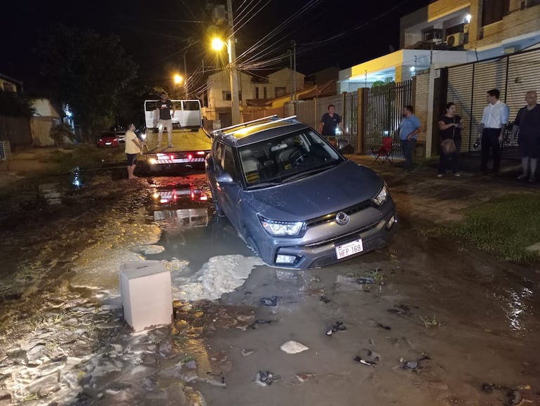 Funcionarios de la Essap llegaron al lugar y ayudaron a sacar el vehículo del pozo.