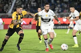 El defensor de Guaraní Imanol Segovia intenta frenar la marcha del debutante Gabriel Ávalos.