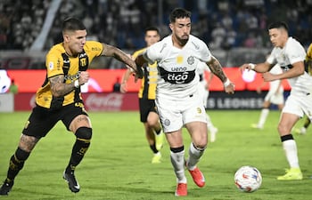 El defensor de Guaraní Imanol Segovia intenta frenar la marcha del debutante Gabriel Ávalos.