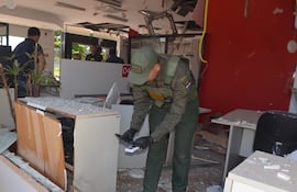 Un militar inspecciona la sucursal de Sudameris que fue atacada con explosivo esta madrugada.