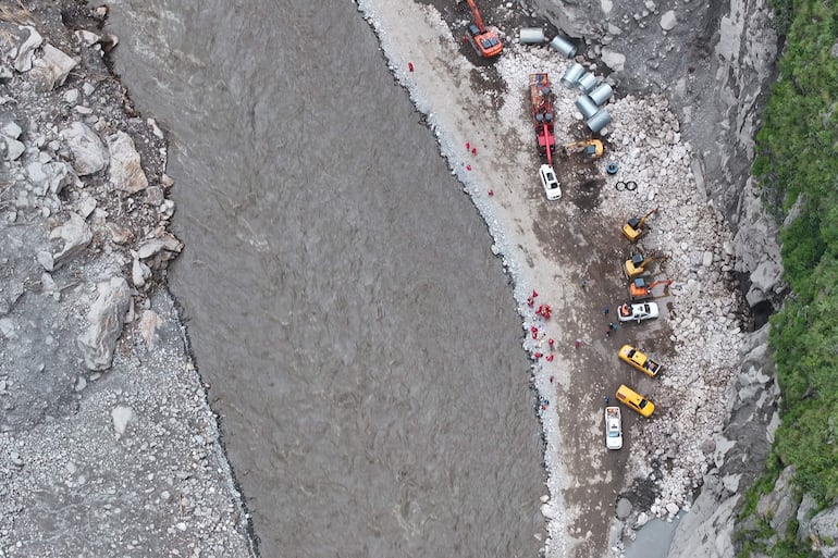 Excavadoras trabajan para reconstruir un camino afectado por la riada en la zona de Gyirong, China.