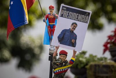 AME8770. CARACAS (VENEZUELA), 05/01/2025.- Una persona sostiene un muñeco que representa al fallecido presidente de Venezuela Hugo Chávez con un cartel con la imagen del presidente de Venezuela, Nicolás Maduro, en un acto por el inicio del año legislativo de la Asamblea Nacional (AN, Parlamento) de Venezuela este domingo, en Caracas (Venezuela). El Parlamento de Venezuela comenzó el año legislativo, el último del quinquenio 2021-2026, con la juramentación del presidente del país, Nicolás Maduro, como "un nuevo desafío" en el horizonte, para el próximo 10 de enero, anticipó la diputada oficialista Tania Díaz, jefa del Bloque Parlamentario de la Patria. EFE/ Miguel Gutiérrez