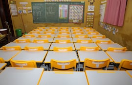 Pupitres encimados en una sala de clases en el departamento Central.
