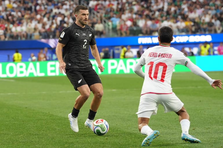 Tim Payne maniobrando frente a Mehdi Ghayedi, en el estreno mundialista entre Nueva Zelanda e Irán (2-2).