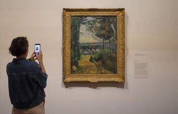 Una persona toma una foto de una obra en "¡Vive l'impressionnisme!" en el Museo van Gogh de Ámsterdam este viernes con motivo del 150 aniversario de este movimiento.