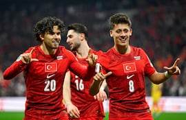 El defensa de Turquía #20, Ferdi Kadioglu (izq.), celebra con el centrocampista de Turquía #16, Ismail Yuksek (centro), y el centrocampista de Turquía #08, Arda Guler (der.), tras anotar el primer gol de su equipo durante el partido de fútbol de semifinales del play-off de la fase de clasificación europea para la Copa Mundial de la FIFA 2026 entre Turquía y Rumania, en el estadio Besiktas Park, en Estambul.