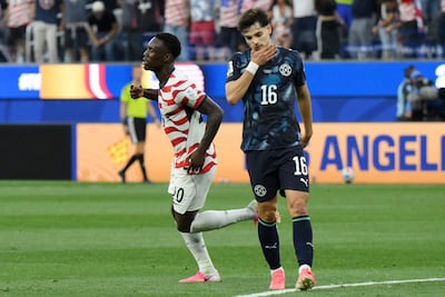 El delantero de Estados Unidos Folarin Balogun (izq.) celebra anotar el tercer gol de su equipo ante el mediocampista de Paraguay Damián Bobadilla durante el partido de fútbol del Grupo D de la Copa Mundial 2026 entre Estados Unidos y Paraguay en el Los Angeles Stadium en Inglewood.