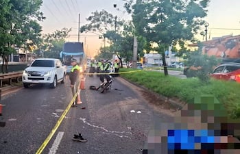 Policías en uniformes, gestionando el tráfico tras un accidente. Una persona herida en el suelo rodeada de autoridades.