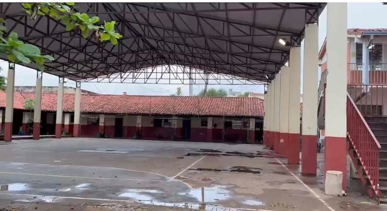 Gimnasio de la Escuela Jorge Sebastián Miranda, con cancha marcada y suelo húmedo, sin presencia de personas.