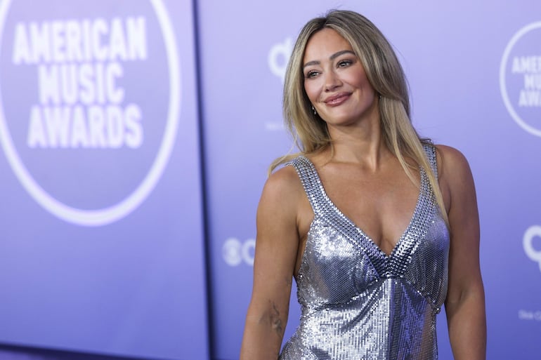 La actriz y cantante Hilary Duff optó por ub look plateado para asistir a los American Music Awards 2026. (EFE/EPA/CHRIS TORRES)