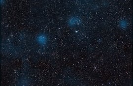 Esta imagen del telescopio espacial James Webb de la NASA, que contiene casi 800.000 galaxias, está superpuesta con un mapa de materia oscura, representada en azul. Los investigadores utilizaron los datos de Webb para detectar esta sustancia invisible a través de su influencia gravitatoria sobre la materia visible.