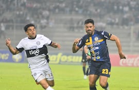 El extremo de Olimpia, Rodney Redes intenta escapar del lateral de Sportivo Trinidense, César Benítez.