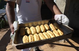 Una persona sostiene una bandeja con chipas en la celebración del Chipa Apo este martes, en Asunción.