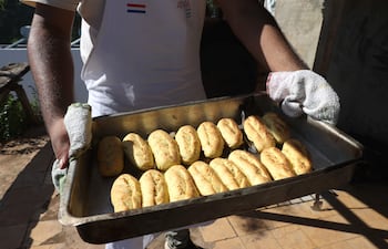 Una persona sostiene una bandeja con chipas en la celebración del Chipa Apo este martes, en Asunción.