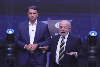 El presidente de Brasil y candidato a la reelección, Luiz Inácio Lula da Silva (d), y el opositor Flávio Bolsonaro, hablan en el primer debate presidencial este domingo, en la sede de Rede Bandeirantes en Sao Paulo (Brasil).
