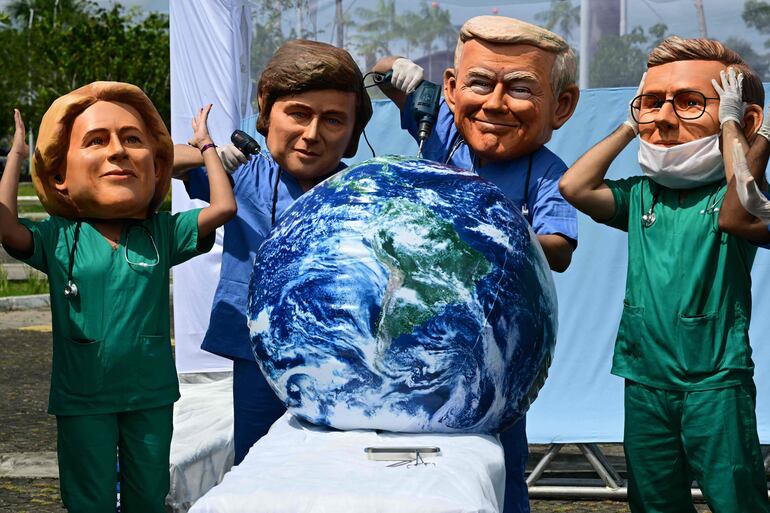 Activistas de Oxfam con mascarillas de gran tamaño que representan (de izq. a der.) a la presidenta de la Comisión Europea, Ursula von der Leyen; el presidente argentino, Javier Milei; el presidente estadounidense, Donald Trump; y el primer ministro británico, Keir Starmer, posan durante su protesta "Cabezudos" en el Parque Utinga de Belém.