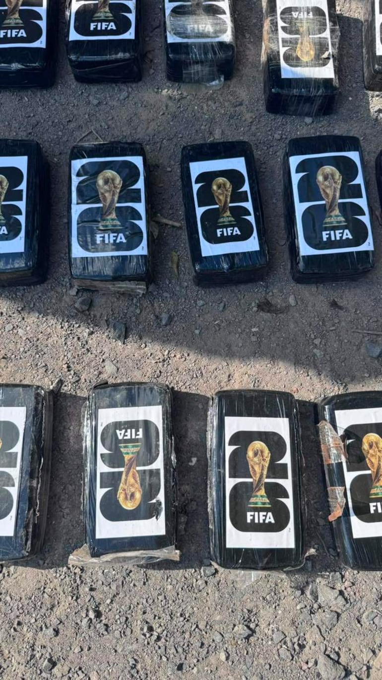Paquetes de cocaína tipo crack dispuestos en hileras sobre tierra, con etiquetas que incluyen el logotipo de FIFA.