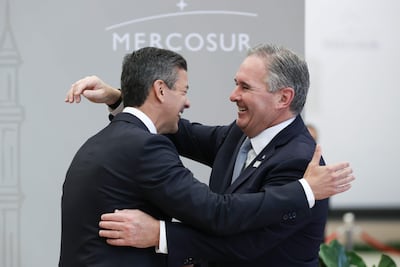 El presidente de Paraguay, Santiago Peña (i), saluda al canciller de Argentina, Pablo Quirno.