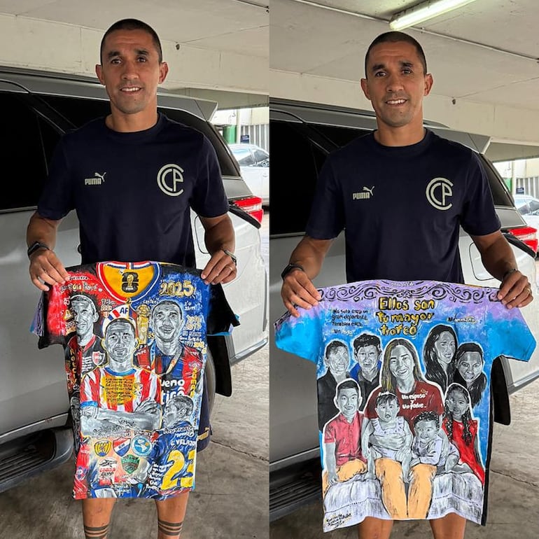 El futbolista Gustavo Velázquez mostrando feliz la camiseta pintada por Ignacio Villalba. (Gentileza)