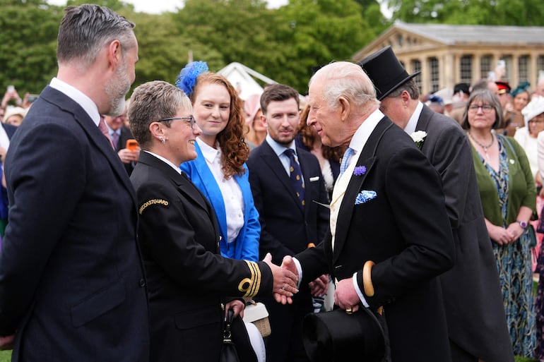 El rey Carlos III conversa con los invitados durante una fiesta real en los jardines del Palacio de Buckingham. (Aaron Chown / POOL / AFP)