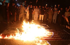 Manifestantes queman banderas de Estados Unidos, Israel e India durante una protesta el pasado lunes en Hyderabad, Pakistán.