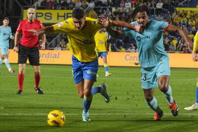 LAS PALMAS DE GRAN CANARIA, 04/01/2024.- El centrocampista de la UD Las Palmas Máximo Perrone (i) disputa un balón con el defensa del FC Barcelona Jules Koundé (d) durante el encuentro de la jornada 19 de Liga en Primera Dicvisión que UD Las Palmas y FC Barcelona disputan hoy jueves en el estadio de Gran Canaria, en Las Palmas. EFE/ Ángel Medina G.