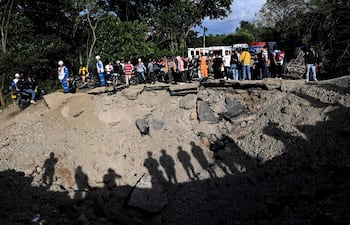 Trabajadores de la Cruz Roja atienden el lugar de una explosión mientras la gente observa tras un atentado con bomba en El Túnel, en la carretera Popayán-Cali, en Cajibio, departamento del Cauca, Colombia, el 25 de abril de 2026. El atentado con bomba del 25 de abril dejó siete muertos y 20 heridos en una zona de Colombia con una fuerte presencia guerrillera, en medio de una ola de ataques a poco más de un mes de las elecciones presidenciales, según informó el gobernador de la región del Cauca.