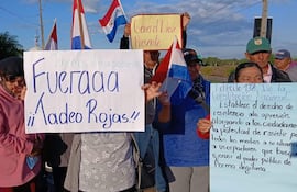 Grupo de adultos mayores en manifestación, sosteniendo carteles y banderas paraguayas, expresando descontento y resistencia ante el gobierno.