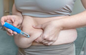 Mujer se aplica medicamento para adelgazar, medicamentos GLP-1, tirzepatida, Ozempic, etc.