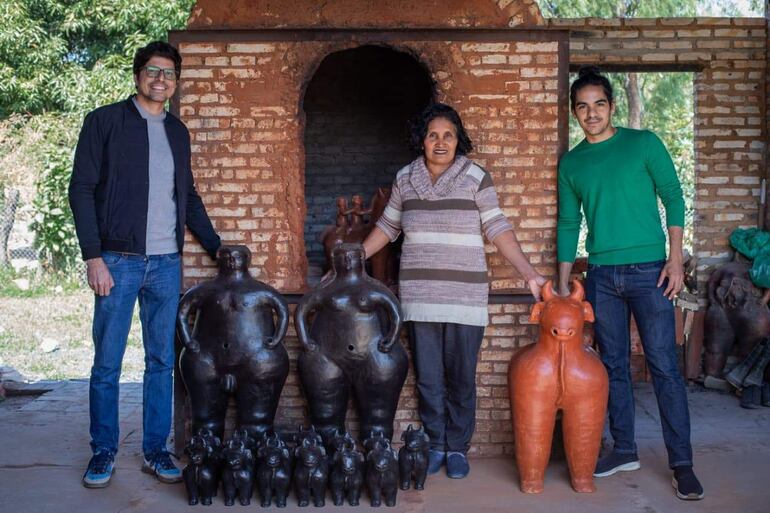 César Centurión, hombre de chaqueta oscura; Ediltrudis Noguera, mujer de camiseta de rayas; y Gustavo Gauto, hombre de suéter verde, sonríen en taller de cerámica.